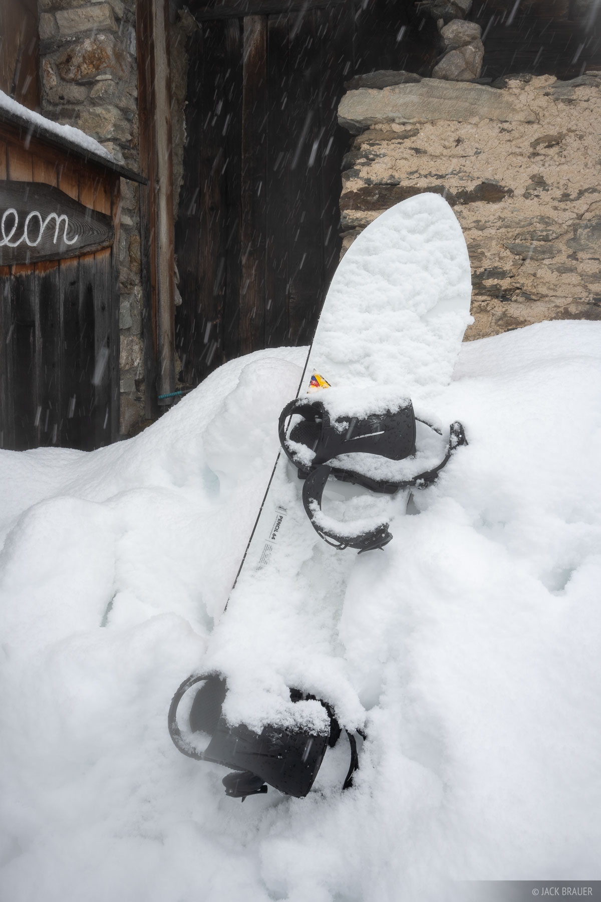Snowboard smothered in fresh powder snow.